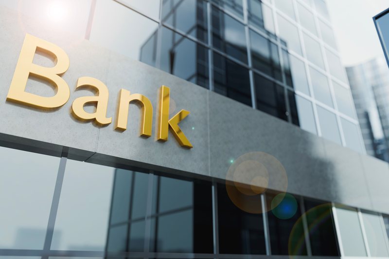 The word Bank in gold letters on the glass facade of a bank building