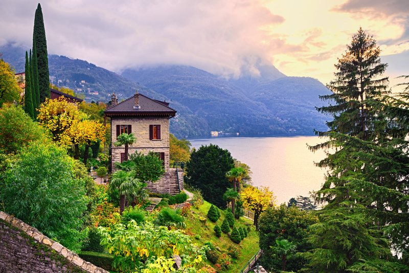 A villa with gardens above a lake in the mountains